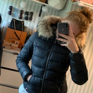 Tommy hilfiger vinterjacka  - En marinblå tommyhilfiger vinterjacka i dun. Sparsamt använd väldigt varm och bekväm. Äkta päls 