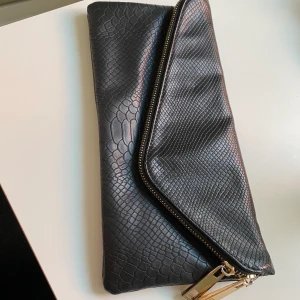 Kuvertväska river island - Svart handväska med ormskinnsyta och gulgiga detaljer, från River Island . 