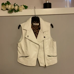 Oanvänd vit skinnväst - Vit skinnväst med leopardmönster på insidan. Oanvänd. Strl eur 140 men passar även xs 