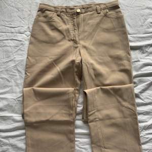 Straight leg and low-waisted beige pants. Fits sizes XS-S. 