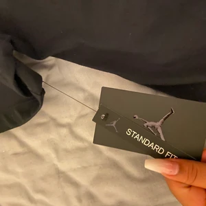 Jordan Paris St Germain T-chirt 2021  - Jordan Paria St Germain t-chirt limmet to one oddisen 2021 svart, en svart Psg/jordan tröja har loggan på både  bak o fram och har en skinande logga på sidan av tröjan. Tröjan är oanvänd och lappen sitter kvar köpte den fast den va för stor för mig det är därför jag säljer den här, kontakta mig om du vill köpa❤️