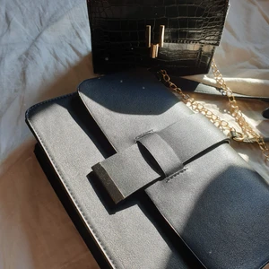 Handväskor till salu! - Säljer två sbarta handväskor! Den ena med ormskin tycker jag är fin men den är plastig, liten men smidig handväska, aldrig kommit till användning! ☺️ Den har ett fint guldigt knäppe och en guldig axelremskedja. Säljer den för 40kr! Den andra mattsvarta väskan är stor och har ett magnet fäste som häller den stängd! Den har en fin silver detalj vid knäppet och en mattsvart rem! Mycket fin och rymlig väska! Säljer denna för 90kr 😊 Köparen står för frakt!