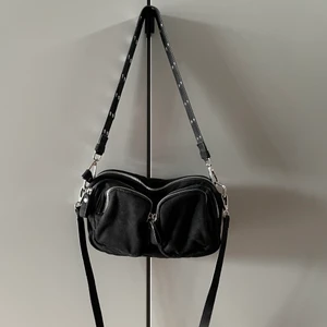 Svart handväska (Noella imitation) - Svart Noella imitation handväska med flera fack, knappt använd. Kommer med två axelband. Köpt från ginatricot. Köparen står för frakten 🖤 🌸