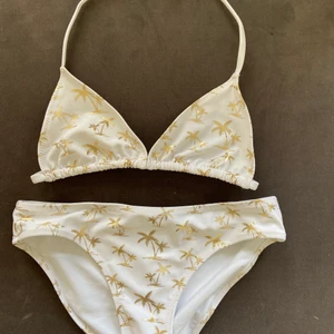 Vit bikini från h&m - Det här är en vit bikini med guldiga palmer från h&m. Aldrig använd.🥰