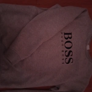 Hugo boss - En grå Hugo boss tjock tröja som jag köpte från kidsbrandstore för 1100 kr och säljer för 400. Den är i storlek 16 år men passar även M-L. Har knappt använt tröjan så den är som ny. 