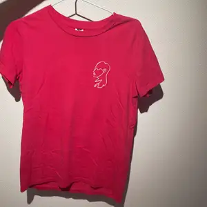 Rosa t-shirt från Visual Clothing Project i storlek S! vitt tryck på vänstra bröstet i from av ett ansikte💓.       Tröjan är mer rosa i verkligheten 💫