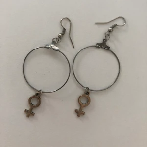 Örhängen med venussymboler - Örhängen med venussymboler. Använd skick. Venussymbolerna är lite repiga (se bild). 