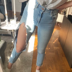 Jeans med hål  - Blåa jeans med hål på ena benet från Zara. Strl 36. 