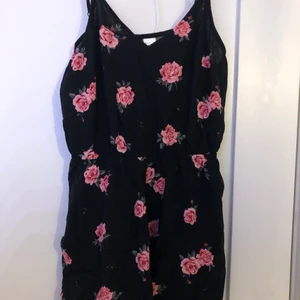 Dress - Säljer denna svarta dress med rosa blommor på i storlek 36. Den har justerbara band.                   Köparen står för frakten!   