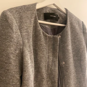 Grå kappa  - Grå kappa från VeroModa, använd fåtal gånger så är i nyskick, säljer då den inte kommer till användning längre 