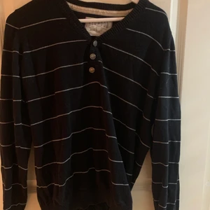 Snygg randig långärmad tröja! - Svart långärmad tröja med vita ränder och knappar, v-ringad.  Snygg design på armbågarna. Strl. M, sitter som L. Betalas via swish, köparen står för frakten:)