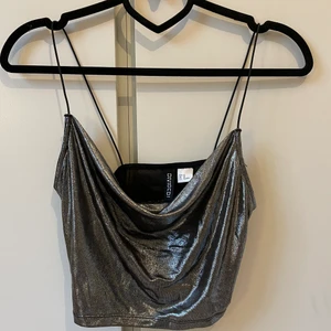 Draperat linne, HM. XS - ⚠️JUST NU 20% på alla mina annonser till den 15/5⚠️!!Ett silvrigt draperat linne från HM i storlek XS. Använd en gång, köpt för ca 100kr säljer för 30:-! Köparen står för frakten.