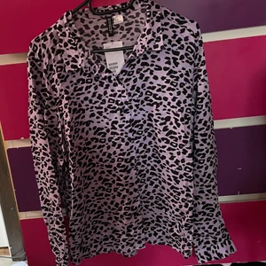 Mönstrad skjorta - Ljuslila skjorta med leopardmönster. Storlek 46, köpt på H&M. Endast testad. 💌Frakten är baserad på frimärken. Önskas postnords egna paket löser vi det. 🎈