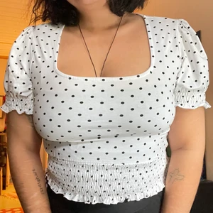 Prickig croptop med puffärm - Supergullig prickig tröja med liten puffärm samt smock i ärmslut och längst ner (midjan typ). Köpt secondhand för 80kr, fortfarande toppskick. aldrig använd av mig. Märke och storlek okänt men uppskattar den till en L. Inte jättegenomskinlig, har ett svart linne under på första bilden. 💌Frakten är baserad på frimärken. Önskas postnords egna paket löser vi det. 🎈