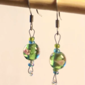 Örhängen, gröna glaspärlor m rosa rosor - Gröna glaspärlor med små rosa rosor. Örkrokar i kirurgiskt stål (nya). 