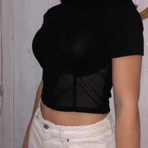Svart mesh topp  - Säljer denna snygga topp från NAKD. Tröjan är i mycket fint skick, då den inte kommit till användning. Tröjan är bara genomskinlig på framsidan under bysten. Köparen står för frakten. Skriv för fler bilder💕☺️