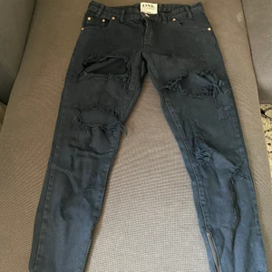 Oneteaspoon jeans svarta  - Ett par jeans från märket Oneteaspoon, de är i storlek 27 och har slitningar på låren. Säljer dessa på grund av att jag inte har den stilen längre. Passformen är mer åt loose fit och passar mig som annars har 34/36 