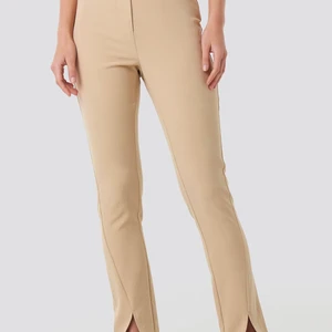 Beiga kostymbyxor med slits  - Säljer dessa super fina kostymbyxorna i färgen beige som har en slits längst ner. Byxorna är super fina och använda ett fåtal gånger. Säljer de pågrund av att de inte kommer till någon användning. 💕