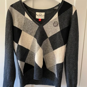 Stickad tröja - En stickad tröja med rutor i vit silver och svart. Tröjan är ifrån espirit och har en silvrig krona på ena sidan. Säljs pågrund av att den var för liten för mig. Det står XL på lappen men den är snarare storlek XS-S