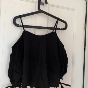 Svart off shoulder topp - En super fin svart off shoulder topp med knytningar vid händerna 🥰 Matrealet är i skojrtmatreal