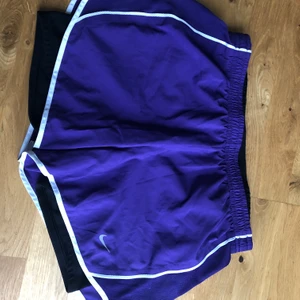 Nike löparshorts  - Lila löparshorts med insydd cykelbyxa. Fint skick! Två fickor för nycklar etc, en med dragkedja. Dragsko i midjan.
