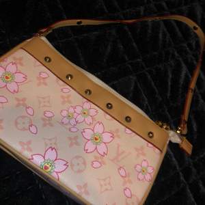 Rosa liten fin Louis Vuitton väska med ett blommigt mönster. Väskan är i fint sick, tror väskan inte är äkta. Kontakta mig vid intresse och fråger. BUDGIVNING I KOMENTARERNA🤩❤️