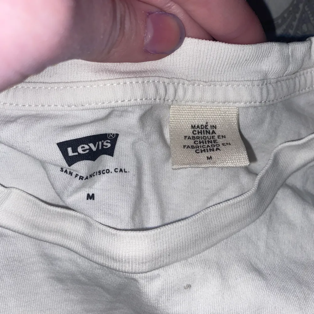 En vit Levis t- shirt med kamouflage tryck i st M. Är använd rätt mycke men har tagit bra hand om den och den är fin i skicket, frakt tillkommer 66kr. T-shirts.