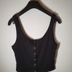 Svart magtröja med knappar - Tröjan är i toppenskick och köptes från H&M. Toppen är i storlek S. Mitt pris:50kr.