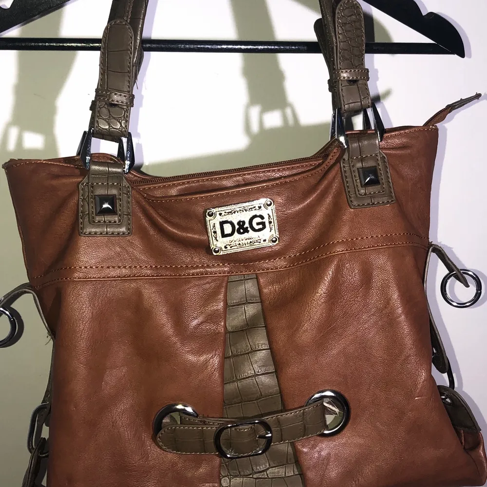 Väldigt fin Dolce&Gabbana-väska i fint skick. Den ända nackdelen är att den är lite sliten på baksidan över dragkedjan. Väldigt rymlig och praktisk, men kommer dock inte till användning längre. Betalning sker via Swish och köpare står för frakten, skriv privat för fler bilder <3. Laukut & Käsilaukut.