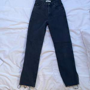 ett par snygga gråa jeans med slits från pull and bear, i storlek 32/xs