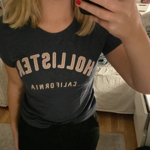 Hollister  - T-shirt från hollister i en mörkblå färg med ljusrosa tryck. Passar xs/s