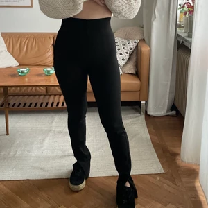 Byxor med slits - Svarta byxor med slits på sidan från Gina Tricot. De har gragkejda på sidan. Köpta för 499 kr använda 2 gånger. Storlek 34 men passar mig som vanligtvis har 36.