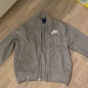 Nike jacka - Ljusgrå Nike jacka med detalj bak med nikelogga, storlek s, mycke fint skick endast använd 2-3 gånger. Säljs pga aldrig används