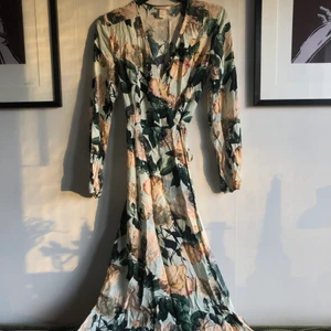 Omlottklänning från H&M trend - Säljer en lång blommig omlottklänning från HM trend i storlek 36 (ganska smal i axlarna) Skick: använd men hel! Perfekt till bröllop eller midsommar! 