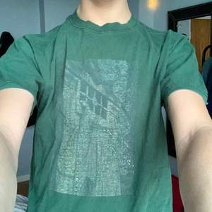 Jättsnygg grön t-shirt med ett coolt tryck som jag säljer då den har blivit för liten för mig. Den är i storlek M men den sitter mer som en S.