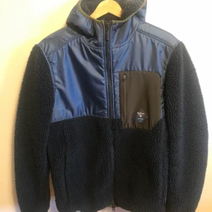 Barbour Beacon jacka i fleece stl M - Jättefin, varm och mysig jacka med huva från Barbour. Luddigt fleece. Storleken M passar S -liten L. Knappt använd i grymt skick. Nypris 1700kr. 