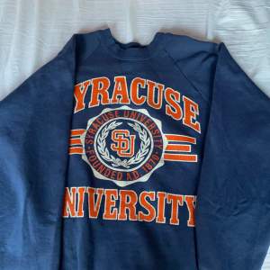 Uneversety swetshirt, köppt på pop butique. Marin blå och orange färg. storlek L men skulle säga att den är storlek M/S. Den har små fläckar på högerarm.