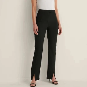 Kostymbyxor från NA-KD - Jag säljer dessa otroligt sköna svarta kostymbyxorna från NA-KDs reborn kollektion eftersom de inte kommer till användning. Materialet är mjukt och stretchigt. De är i storlek 38 och har en dekorativ slits nere vid fötterna. Kontakta mig för mer info❤️