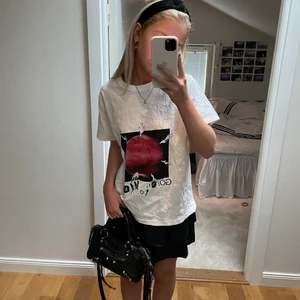Ganni T shirt - Sjukt snygg ganni t shirt köpt i somras , använd ett fåtal gånger. Coolt tryck både på fram och baksida (tröjan är lite skrynklig på bilden men tvättas och stryks självklart innan jag postar) Stor i storleken, passar främst S eller mer overzise XS, köpt för runt 1200