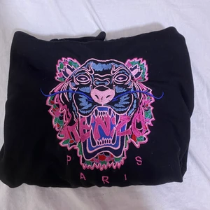 Kenzo Hoodie - En svart väldigt fin Kenzo hoodie. Köpt för ca ett halvår sedan och är sparsamt använd. Används tyvärr inte längre. Nypris ca 2500. Kan skicka fler bilder. Storlek: L i barnstorlek vilket motsvarar ungefär Xs-S i vanlig storlek. Hör av er vid frågor 
