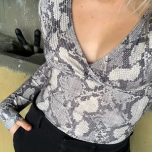 Ormskinnsmönstrad body  - Långärmad v-ringad body från HM som köptes men inte kom till användning. Helt slut såld på hemsidan 🐍 
