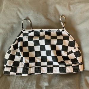 Rutig topp i strl M - Jättesöt schackmönstrad topp i storlek M. Toppen är i jeanstyg och kommer från märket Yamamay. Den är justerbar i banden och på ryggen kan man välja att knäppa den i två olika avstånd.🤎