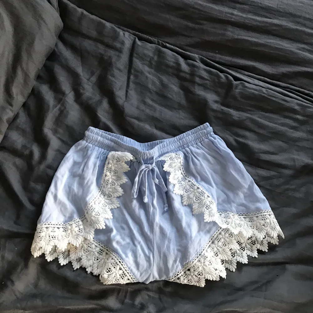Ljusblåa shorts med vit spets ifrån H&M, använda en gång. Shorts.