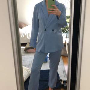 Ett snyggt kostymset från Gina trikå i ljusblå färg. Byxorna är höga i midjan. Köpare står för frakt.