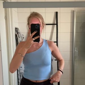 One sholuder croptop - Blått one sholuder linne från Gina tricot i storlek m. Minnet är aldrig använt och därmed i super bra skick. Färgern är super söt. Linnet är lite kortare. Priset går alltid att diskutera. Betalning sker alltid innan jag skickar. +frakt tillkommer💕🤪😋