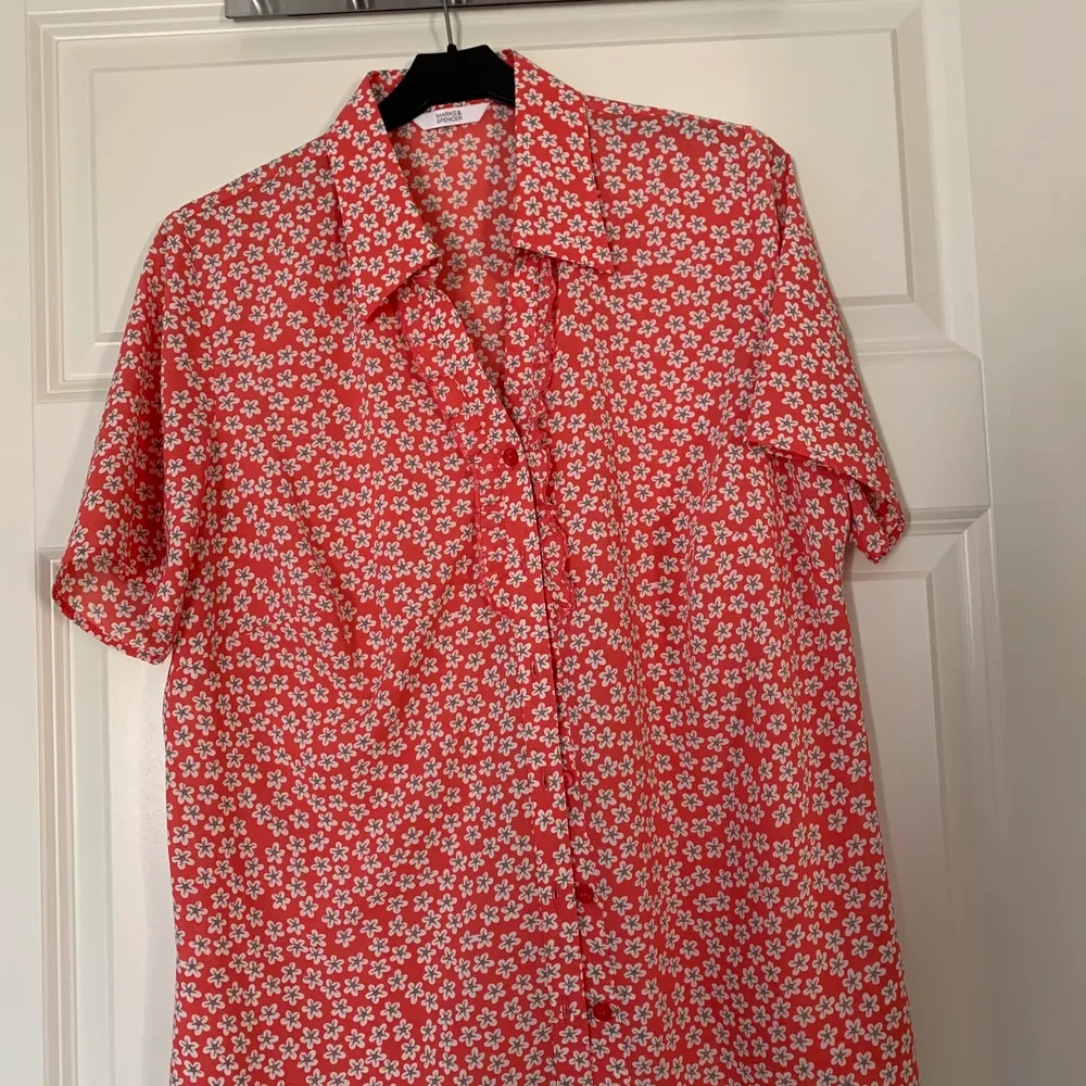 Röd blommig skjorta från Mark & Spencer, skulle säga storlek 38. Skjortor.