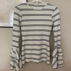 Långärmad tröja  - En otroligt mjuk och fin ribbad och randig topp i storlek s från chiquelle. Den är tajt men ändå väldigt strechig och den är ganska lång i modellen! Ärmar slutar i stora/vida volanger! Frakt tillkommer på 62kr!