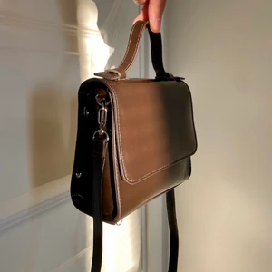 Brun lackväska  - Mörkbrun lackväska från Weekday. Färgen på bild 2 är den  mer ”rätta” färgen. Avtagbar axelrem!  Liten i storleken 😋 Köptes för 300 kr. 