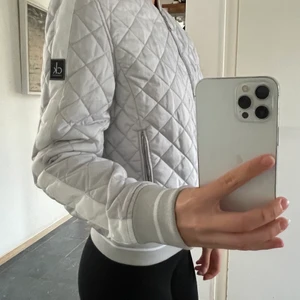 Silvrig Calvin Klein Jacka - Tunnare dunjacka från Calvin Klein jeans i en silver grå färg med vita detaljer! Helt oanvänd, orginalpris 2000kr