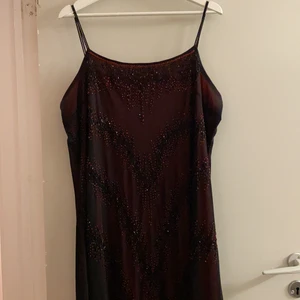 Festklänning  - En lång svart/röd festklänning som är köpt för 800kr men säljs här för 400kr. Man får även med en matchande kofta som är köpt tillsammans med klänningen. Använd endast 2 gånger.                                                                                    Den har ingen storlekslapp men den passar en Xl                Om du vill ha flera bilder eller har några frågor kontakta mig!     Frakt tillkommer!